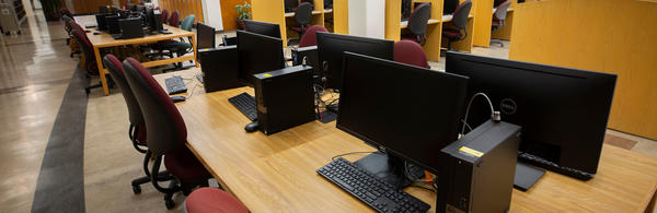 desktop computers on tables in library (c) UCR/Stan Lim